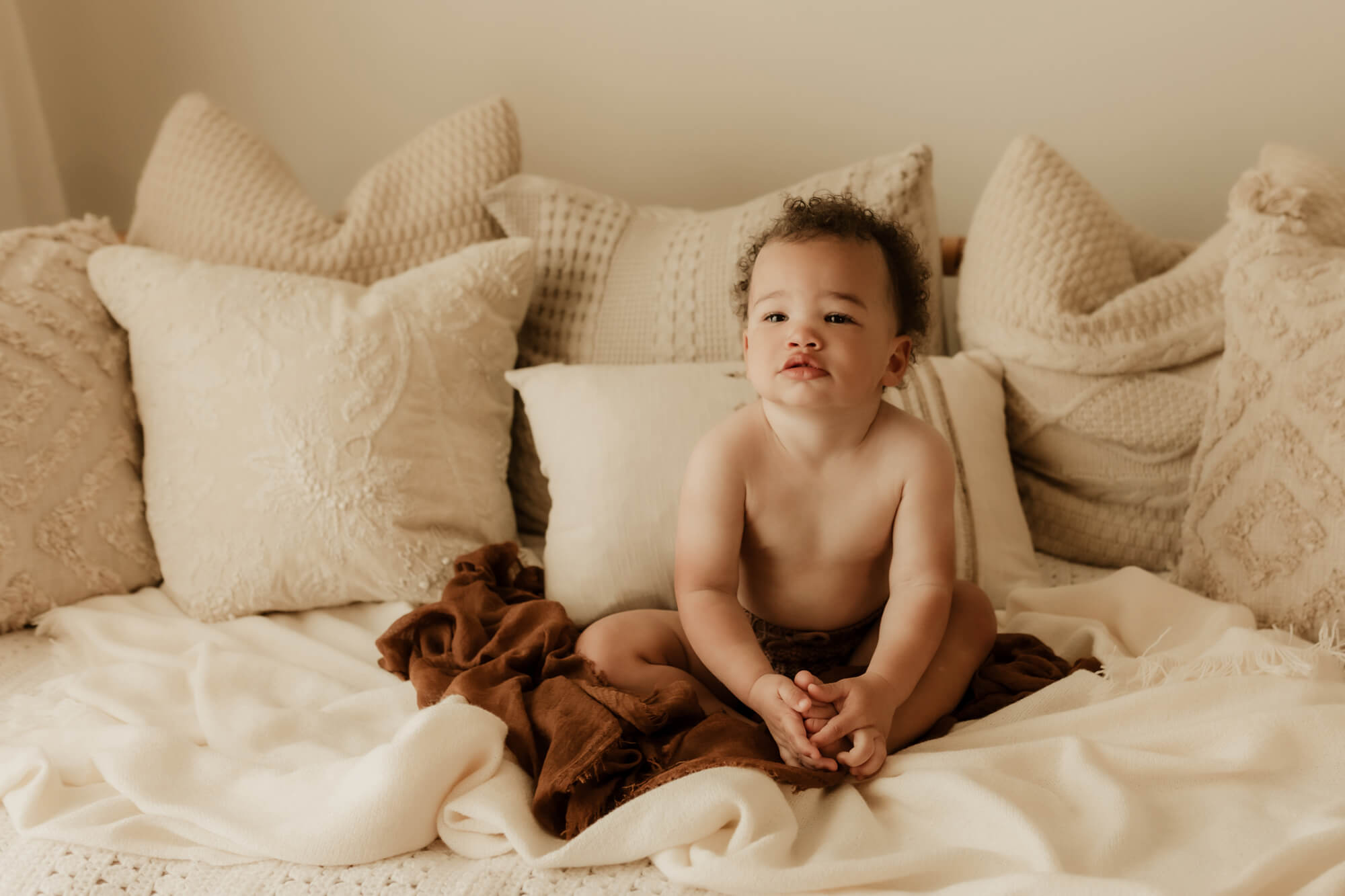 Little boy sits on a bed in Oklahoma City, Oklahoma.