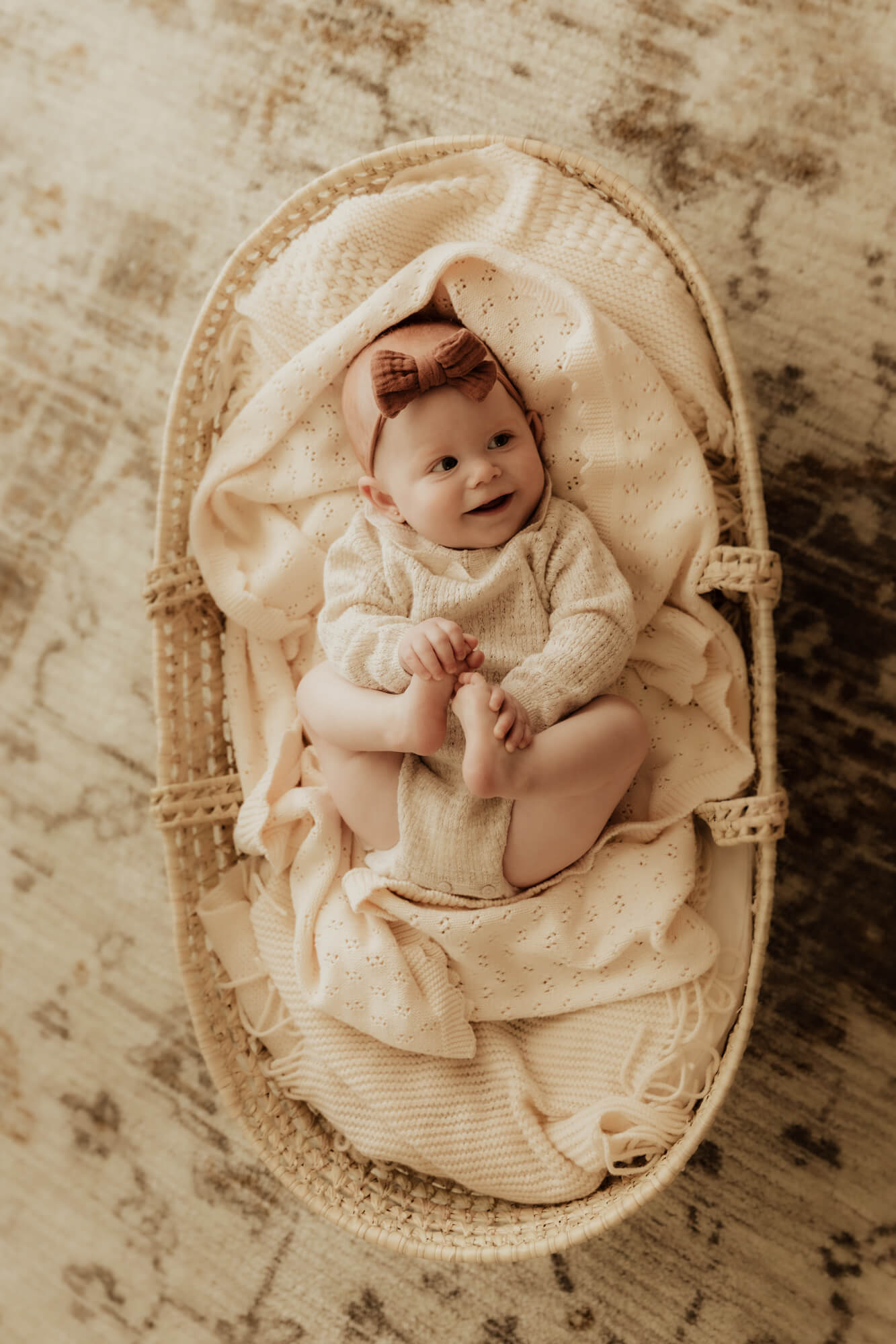 Baby laying in basket and smiling. 