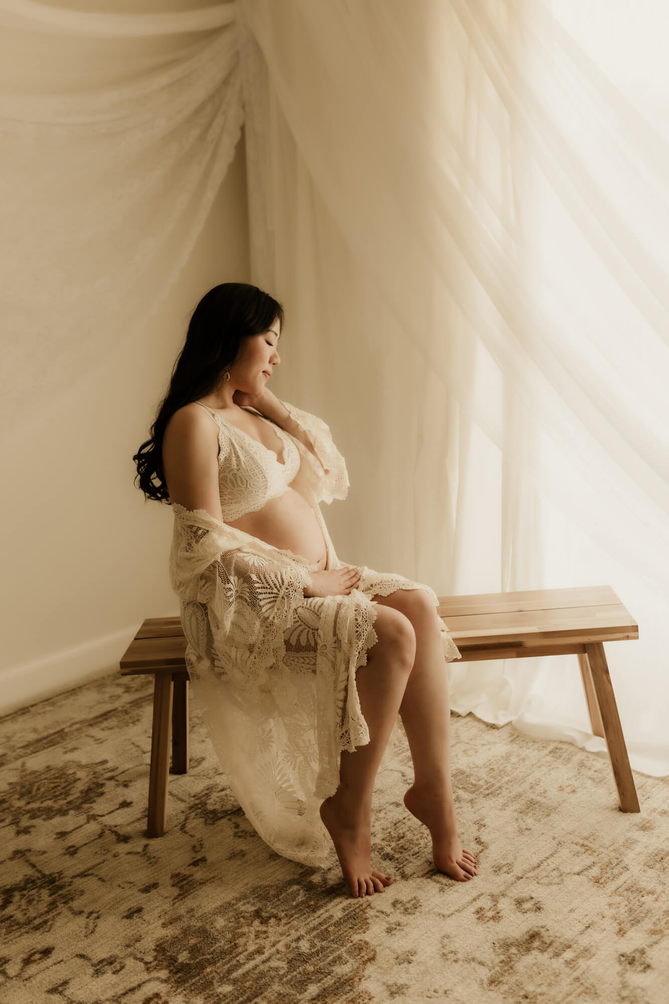 Pregnant mother posed for a maternity portrait while sitting on a bench, prenatal massage okc.