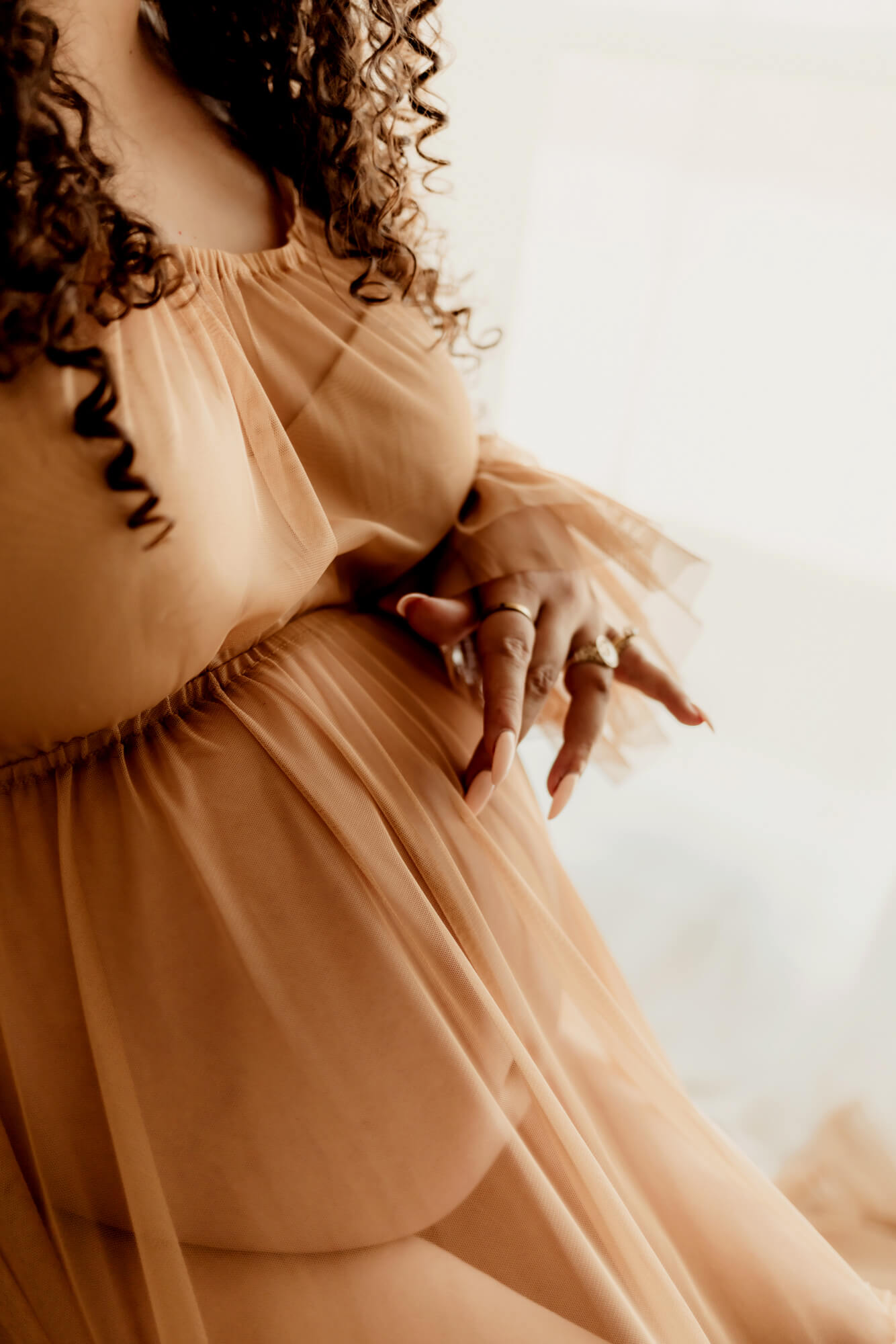 Woman strokes her pregnant belly.