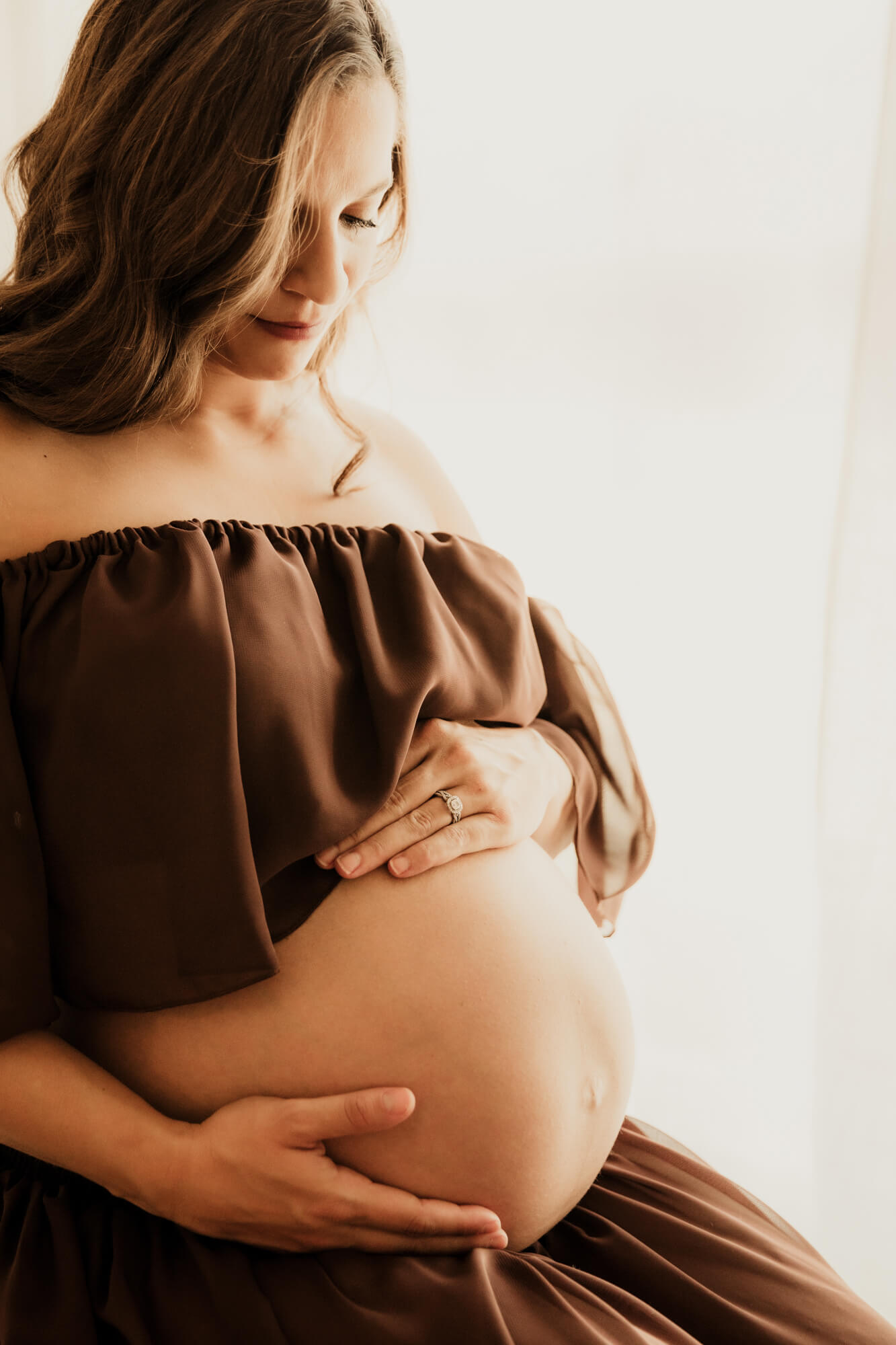 Baby bump photo of a mother wearing a brown two piece dress, Oklahoma midwife.