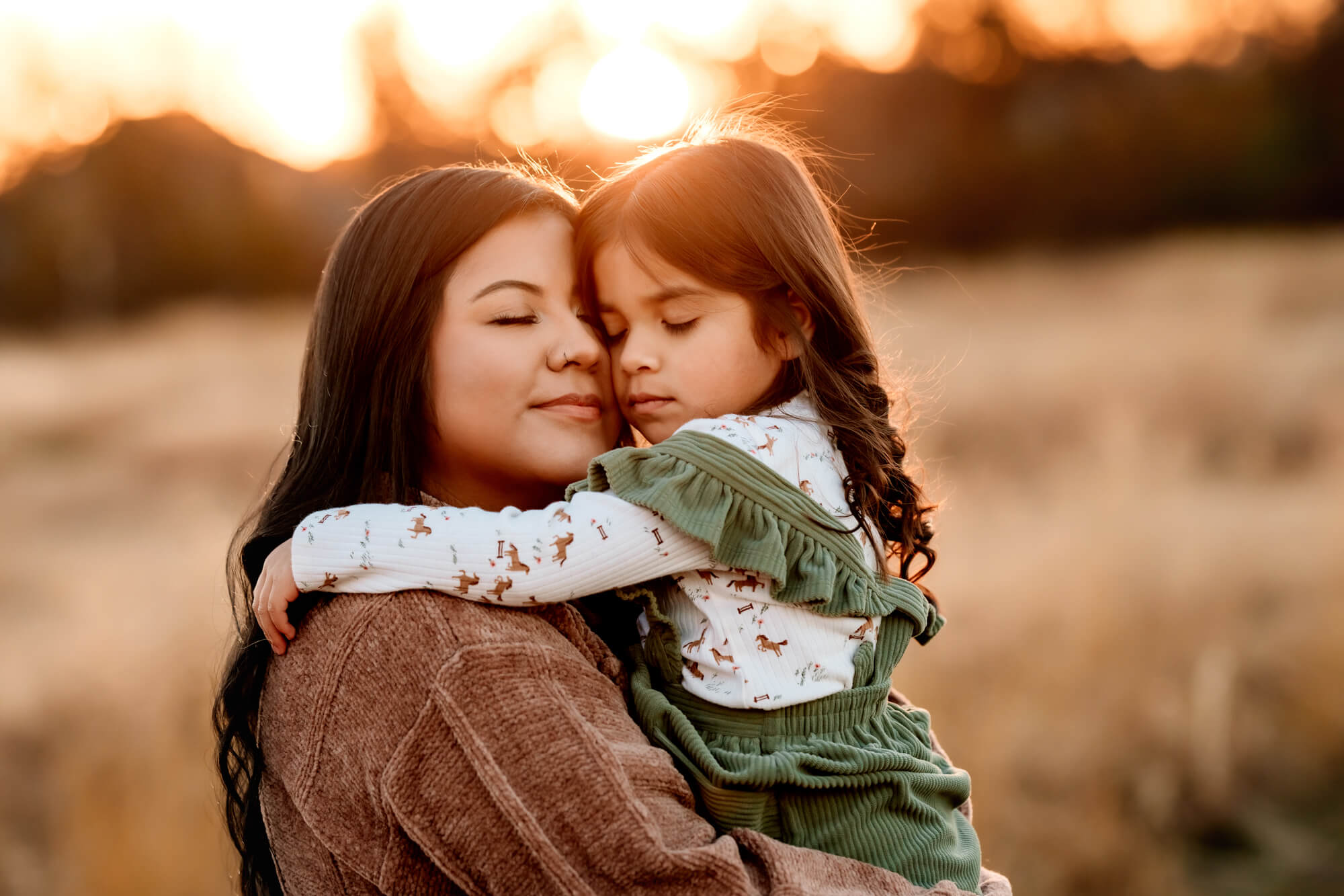 Mom and daughter embrace for a snuggle in a field, mommy and me classes in OKC.
