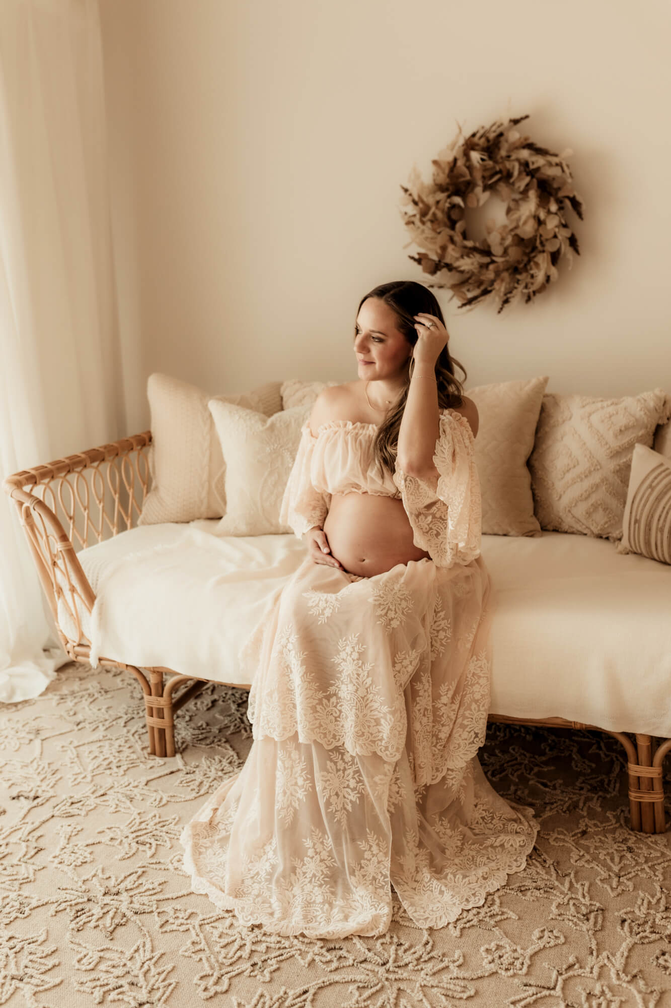 Pregnant mother pulls her hair behind her ear while sitting down, , gynecologist Norman OK. 