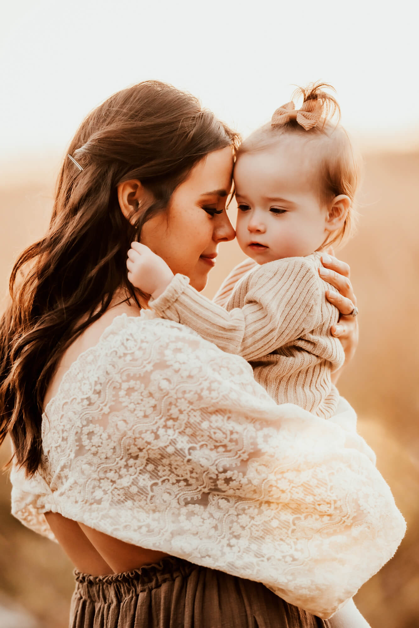 Mother and daughter embracing one another in field, okc parks.