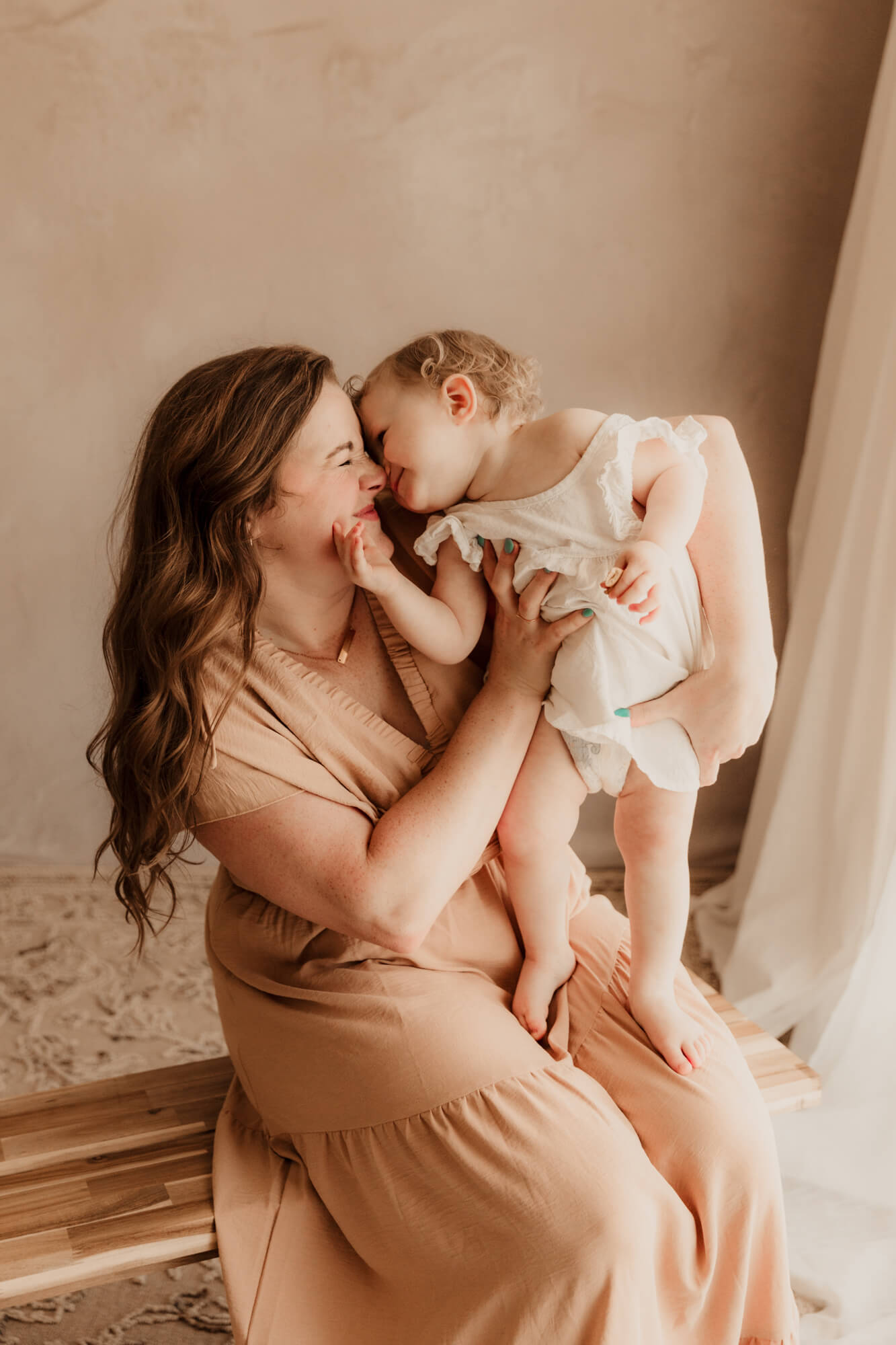 Mother and daughter snuggle one another of a family studio portrait in OKC, Oklahoma Science Museum. 