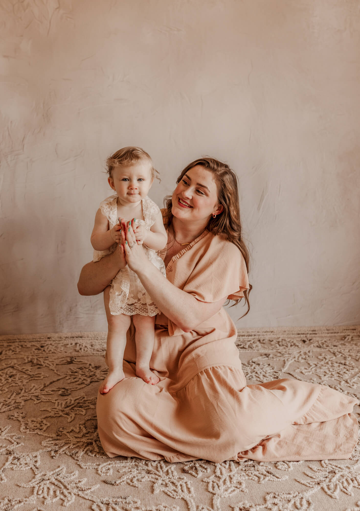 Mother and daughter clap while sitting down. 