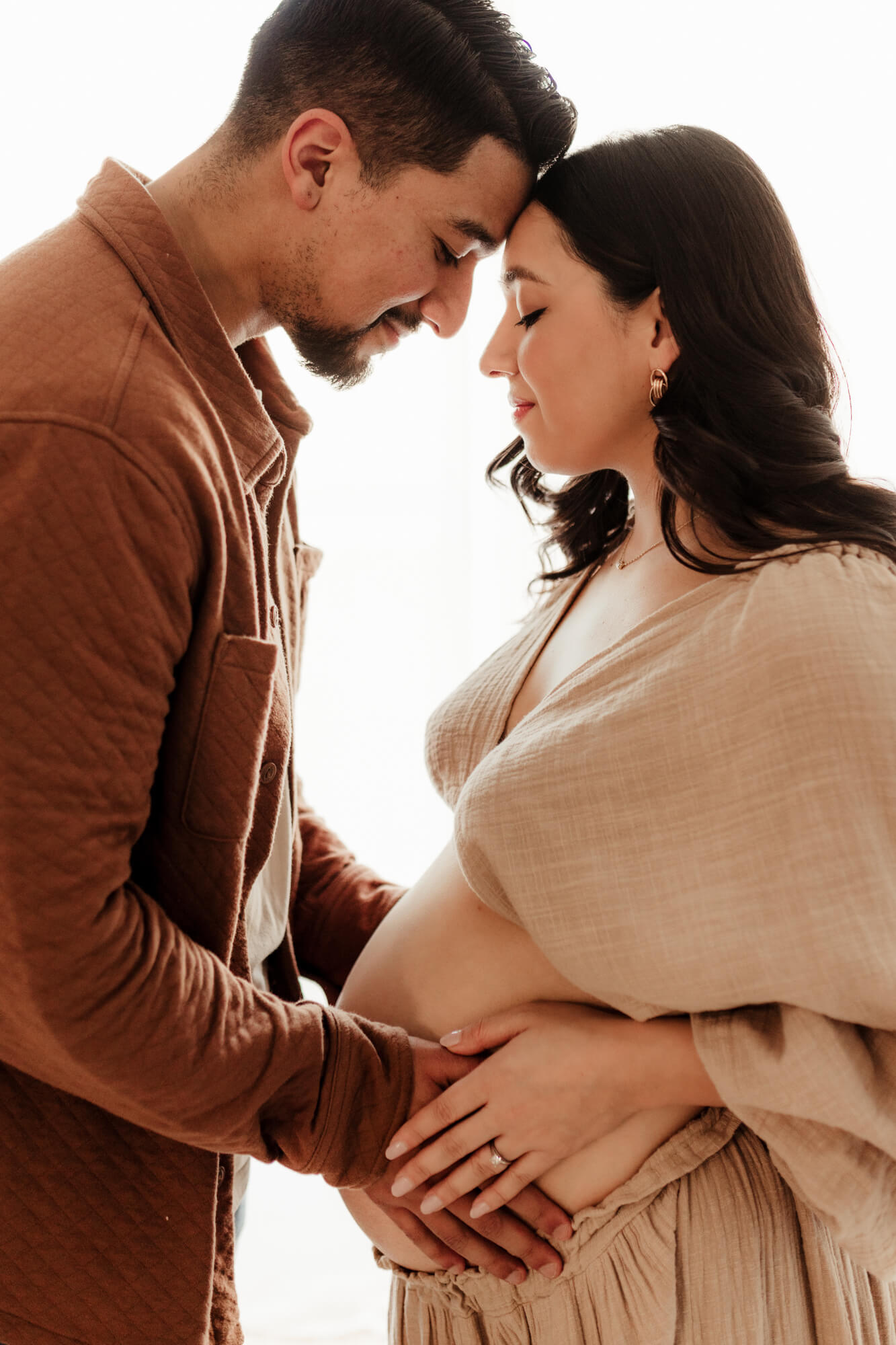 Husband and wife place hands on the mother's belly, birthing center okc.