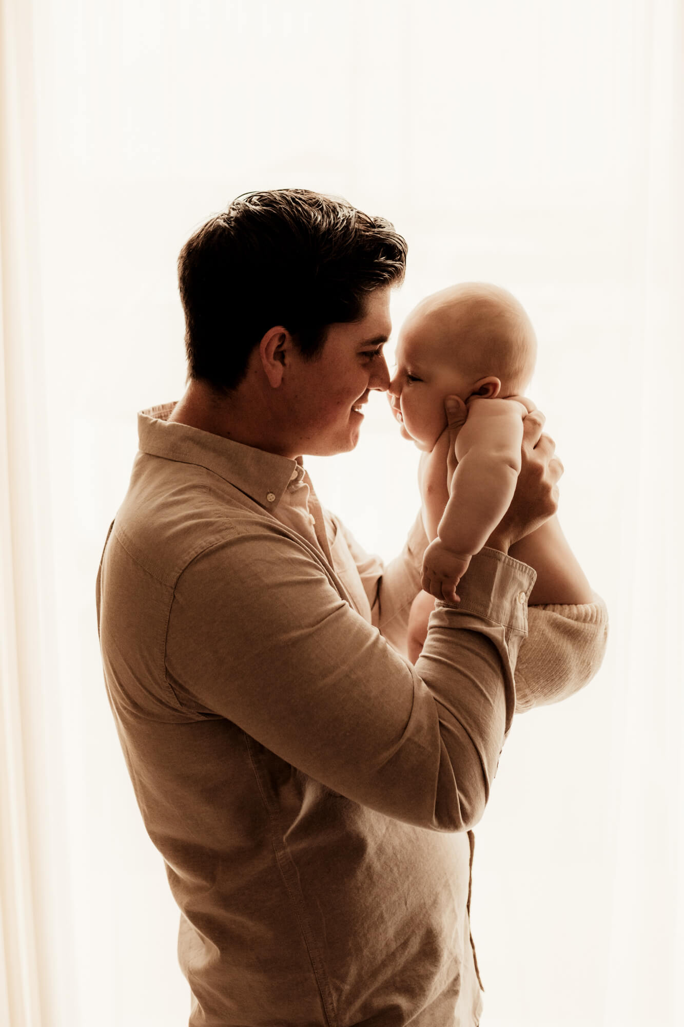 Father touches nose with son, Peek-A-Boo Baby