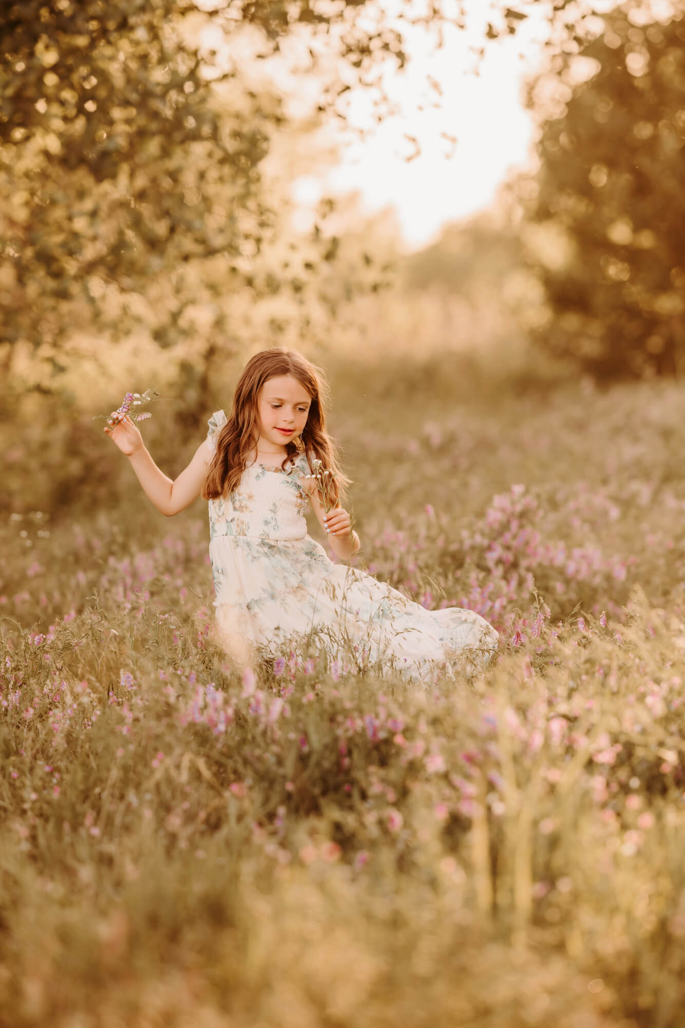Girl smells flower while playing, OKC swim lessons.