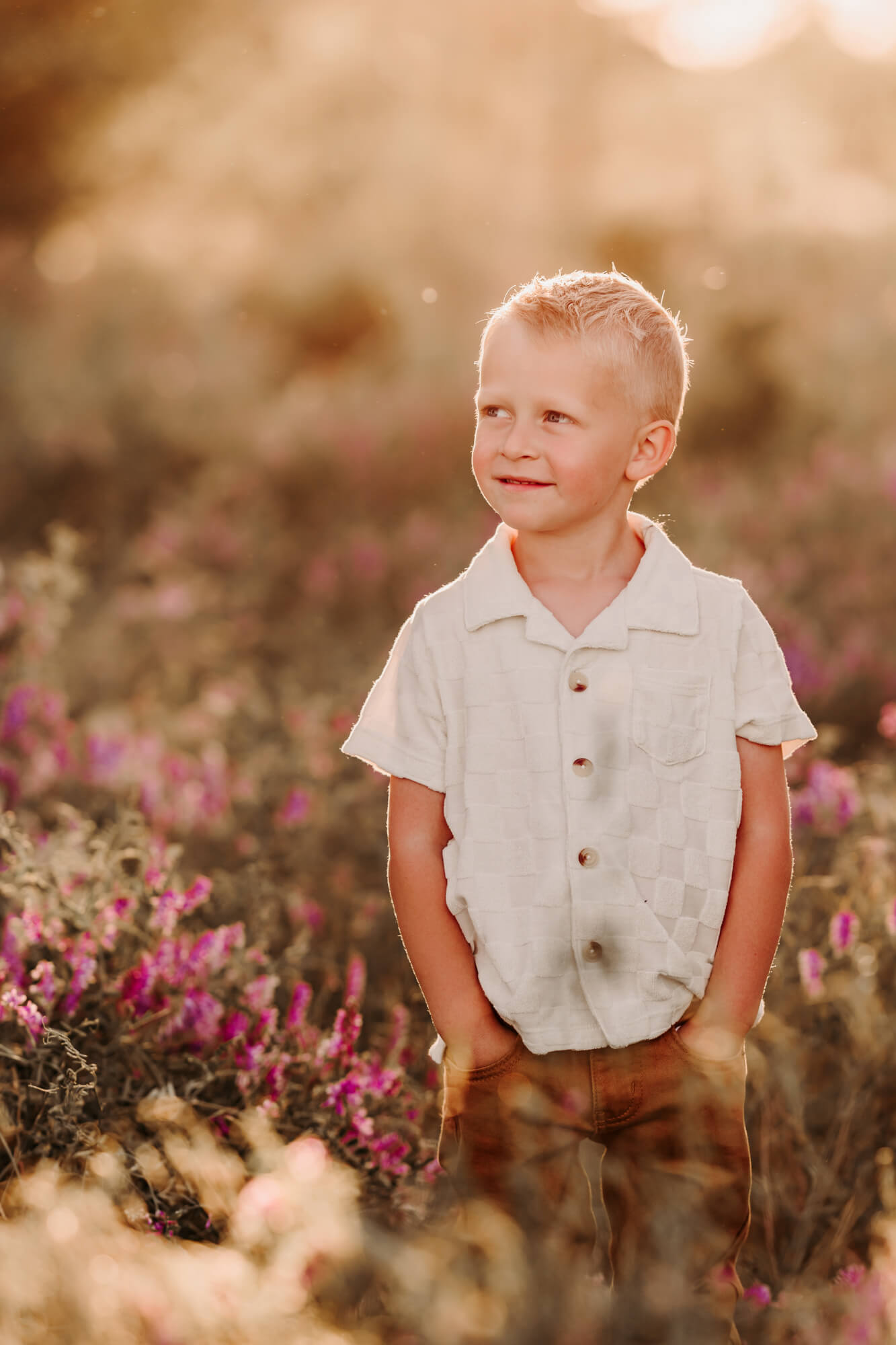 Girl with buttoned shirt smiles while looking to the distance.