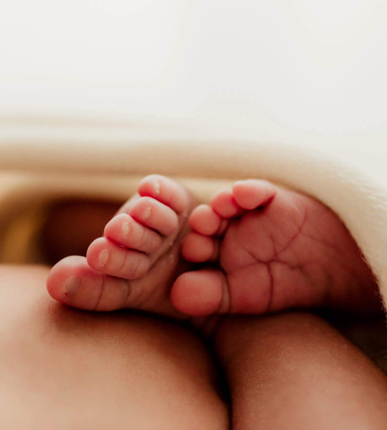 Details of a newborn baby's toes sticking out of a blanket thanks to Oklahoma fertility clinics