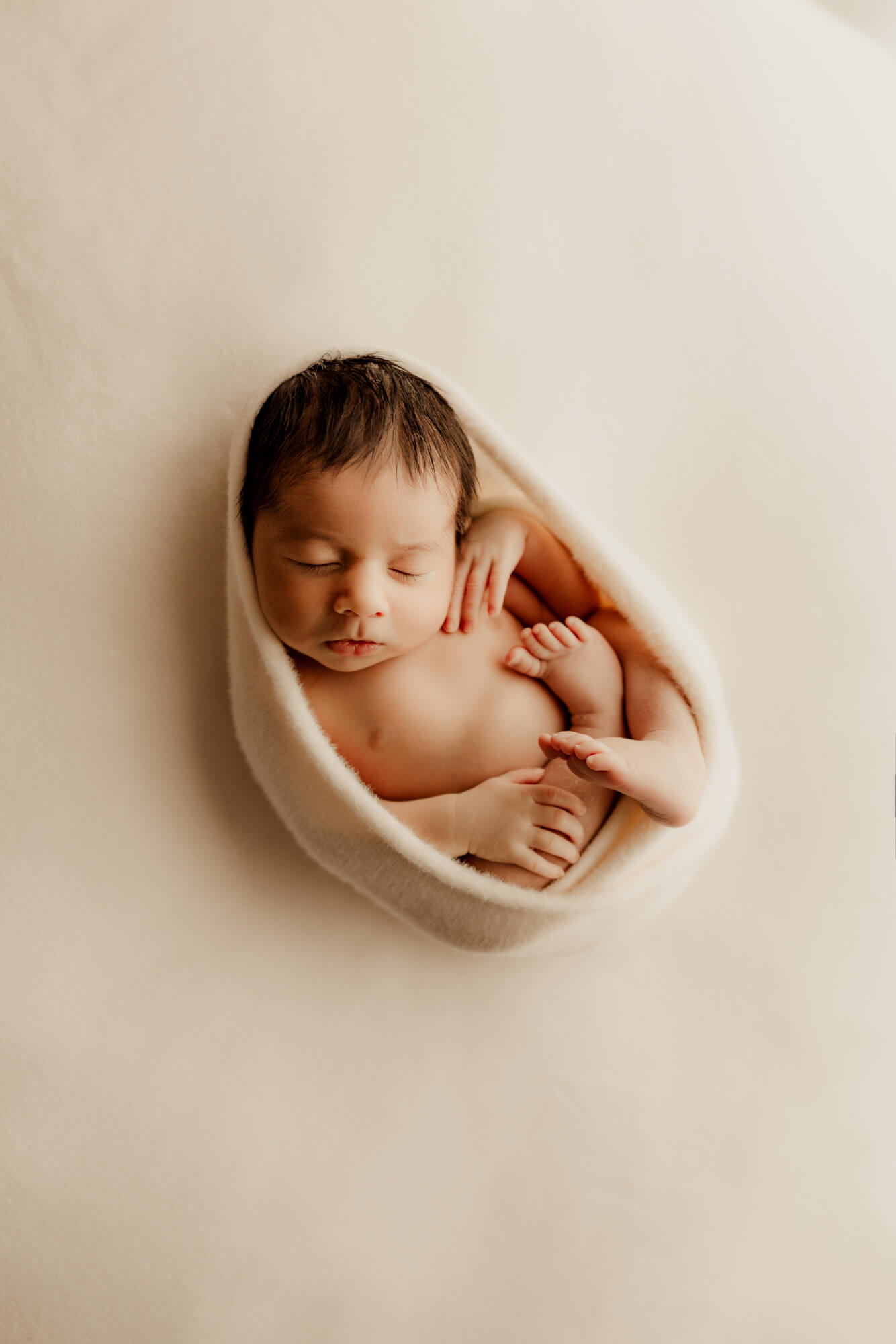 Baby sleeping on a cozy white wrap, Perinatal Center of Okahoma.