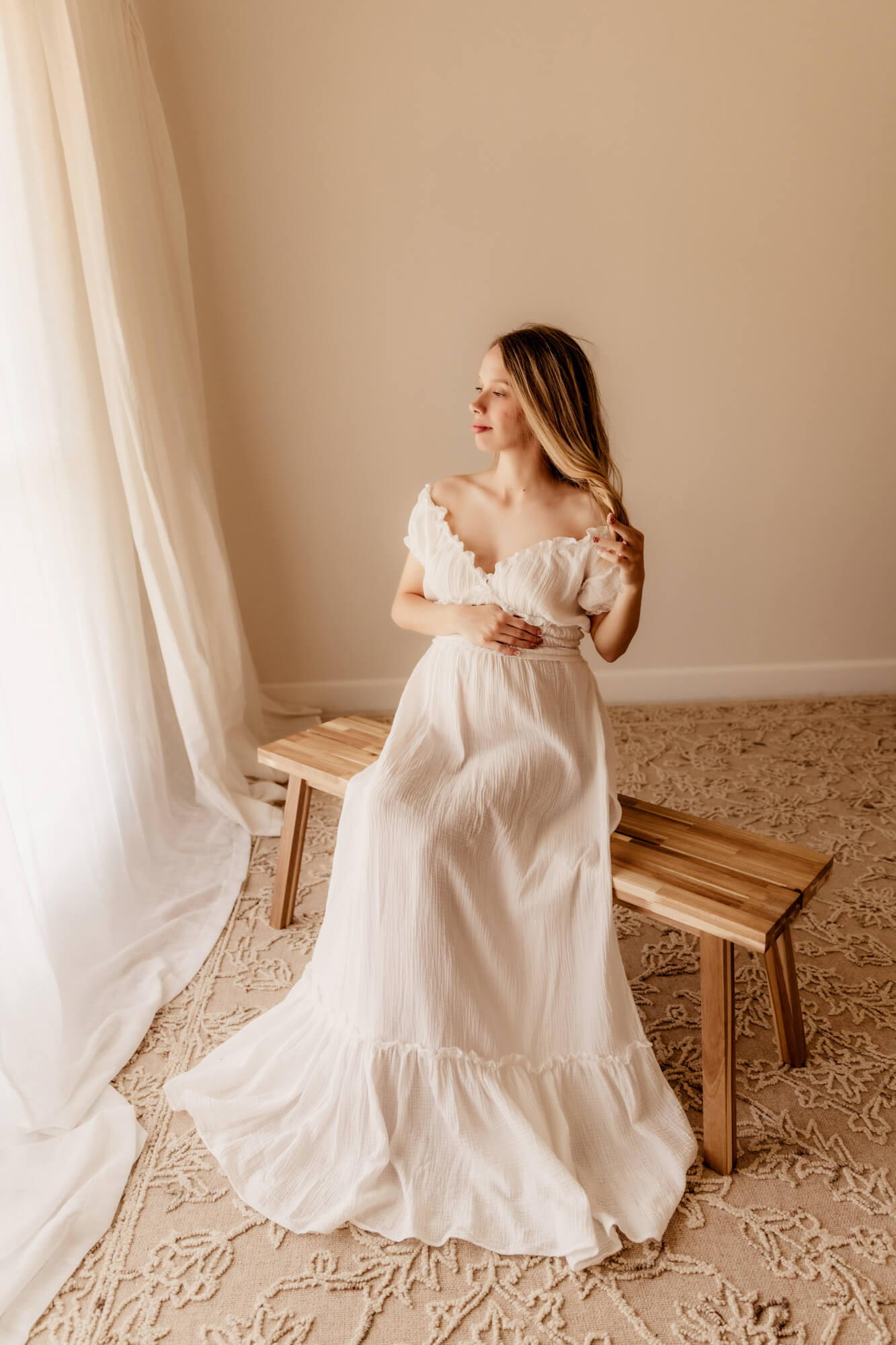 Woman with a white long dress sitting on a bench twirling her hair, OBGYN Oklahoma City OK.