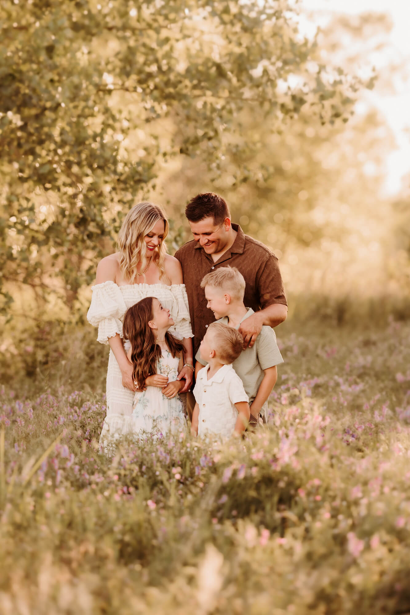 Family of five smiling at one another.