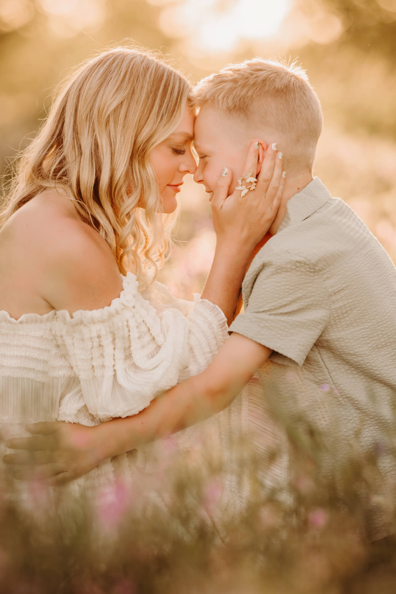 Mother and son touch noses during an evening sonset.