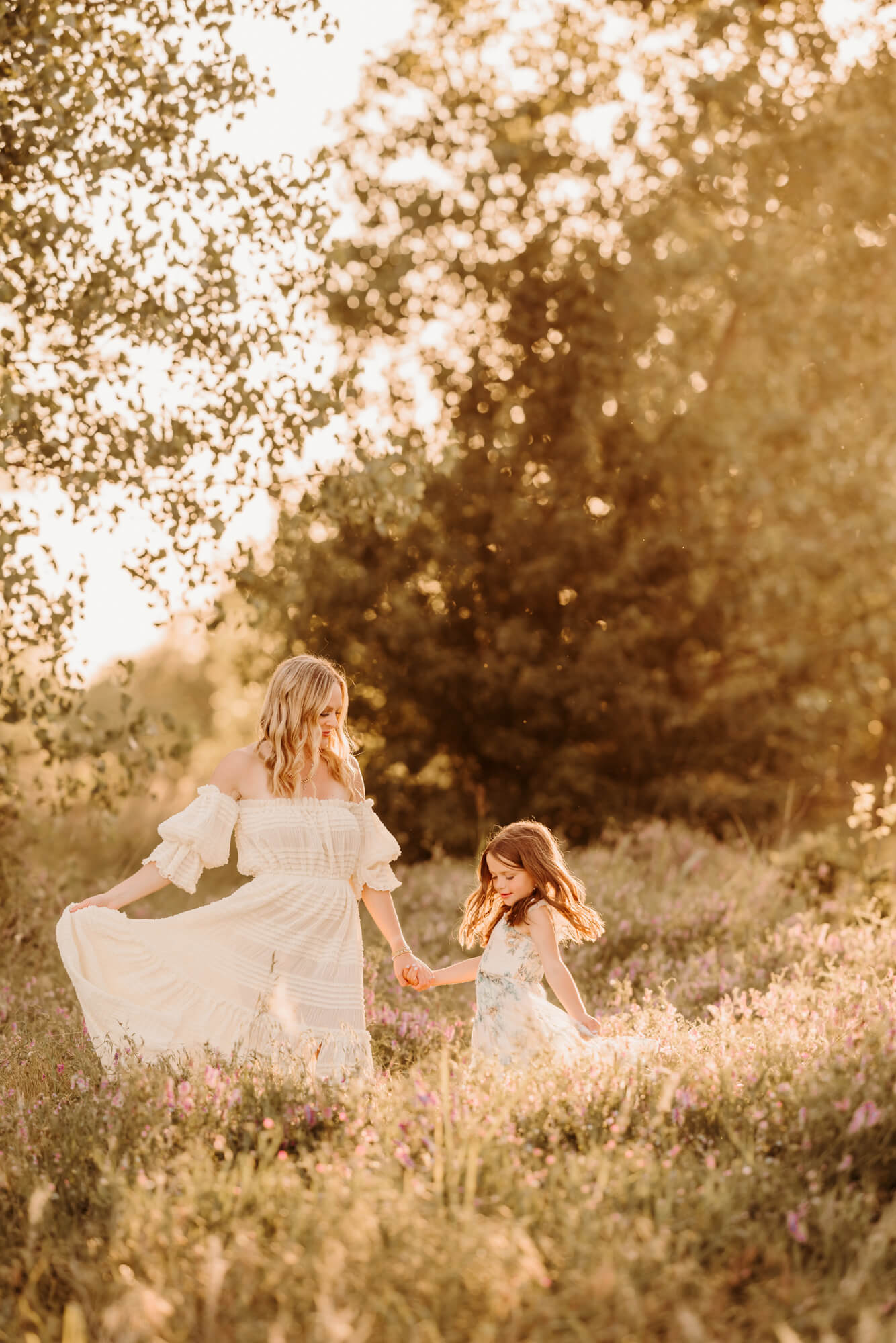 Mother and daughter dance in a field of purple flowers, OKC family fun.