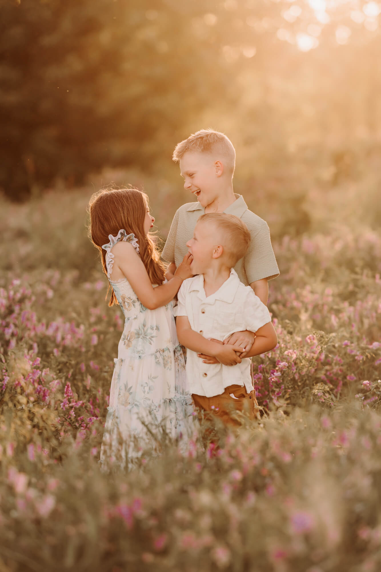 Siblings laughing in a field of purple flowers, OKC family fun.