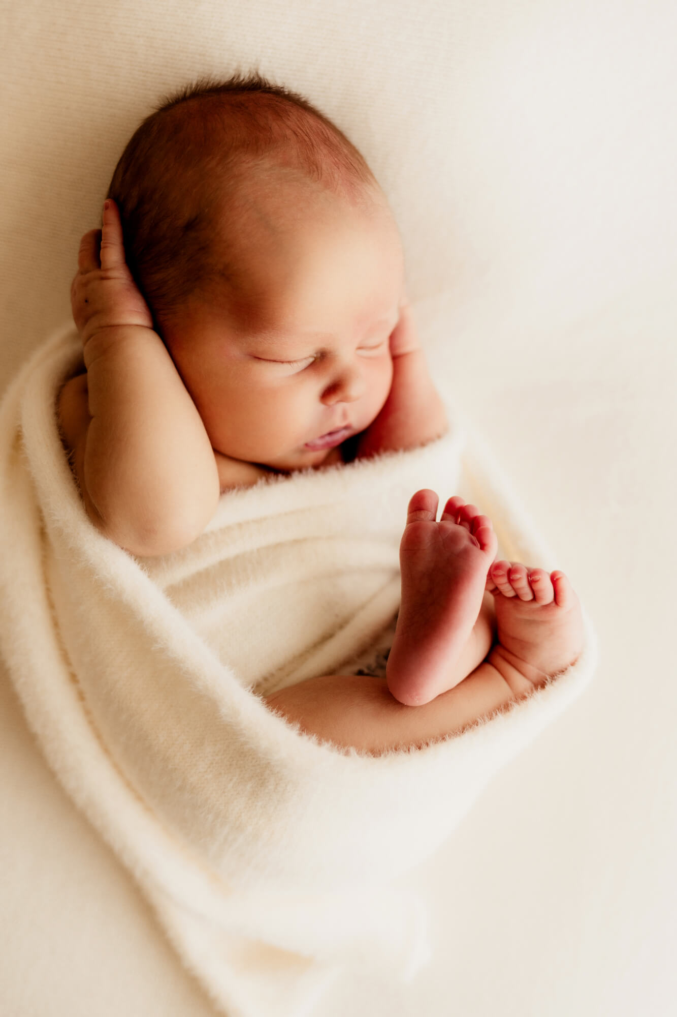 baby boy wrapped in a white swaddle wrap with his armed by his head, Oklahoma City 3D ultrasound.