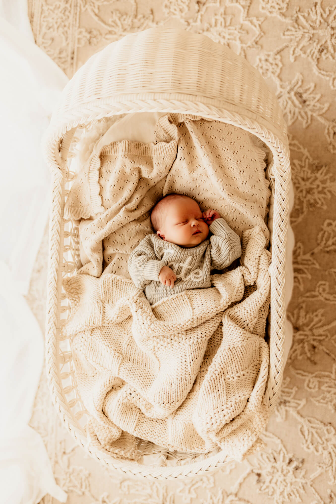 Baby boy with a sage sweater sleeping in a white bassinet, Oklahoma City 3D ultrasound.