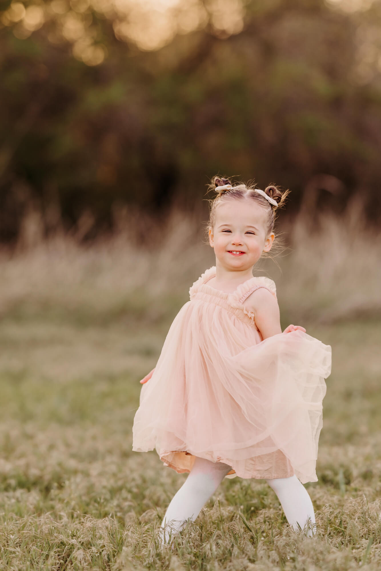 Girl holds her dress up while smiling with personality.