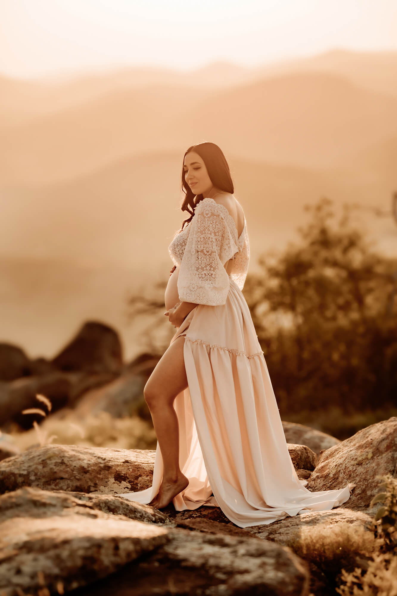 Woman wearing a white skirt and white lace top posed for a maternity photo, Perinatal Center Tulsa.