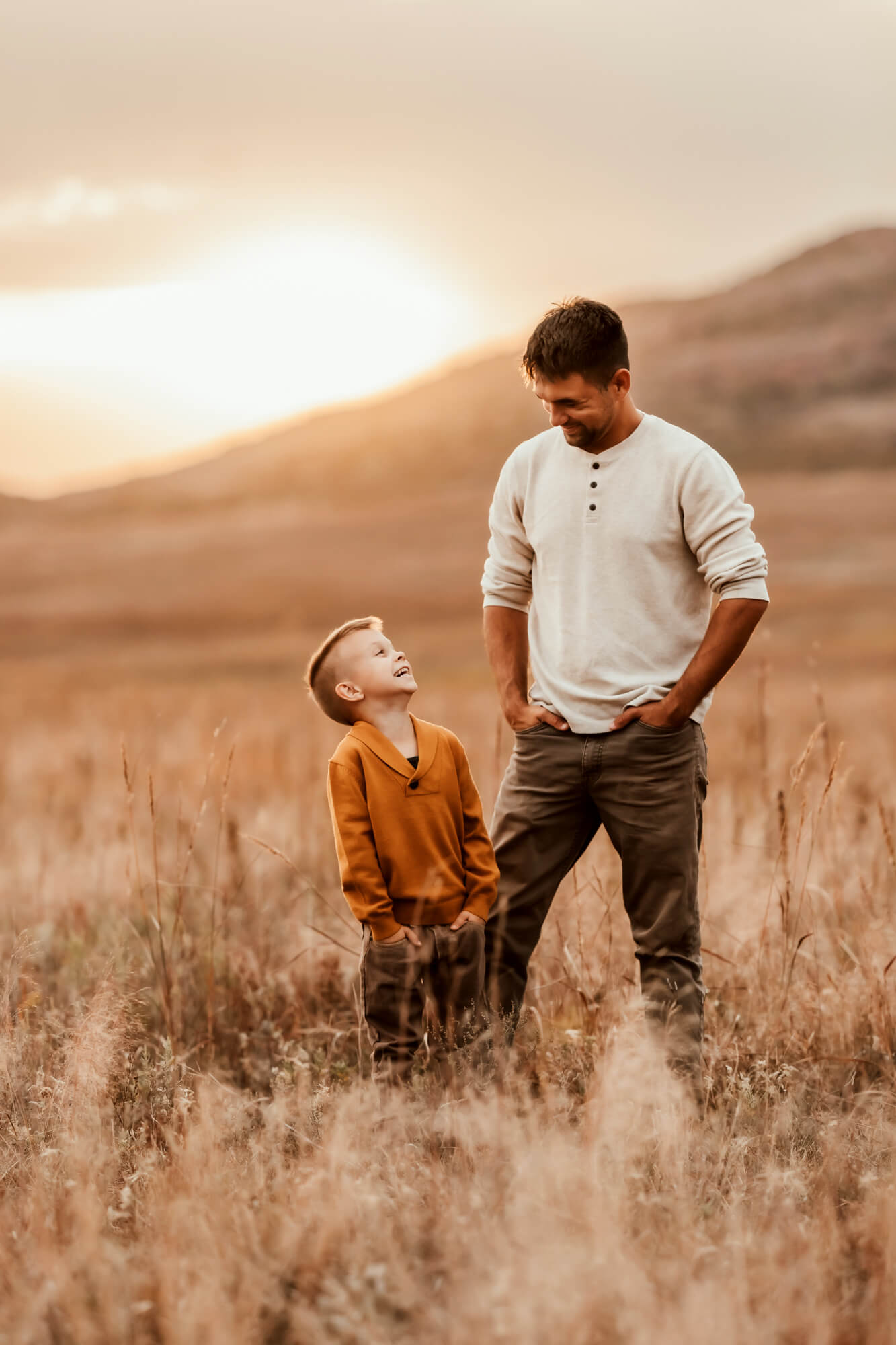 Father and son look at one another during a sunset near a mountain, Kidoodles Norman OK.