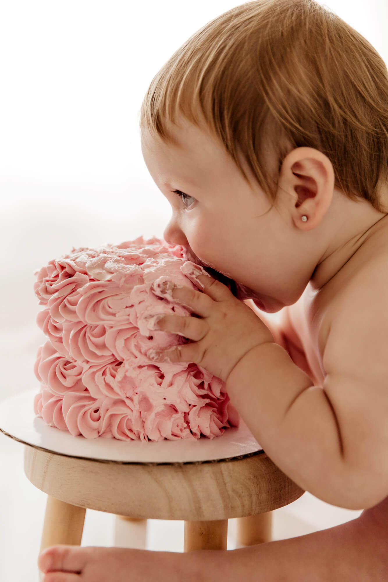 Baby girl who is turning one year's old takes a bite of her cake, OKC birthday party.