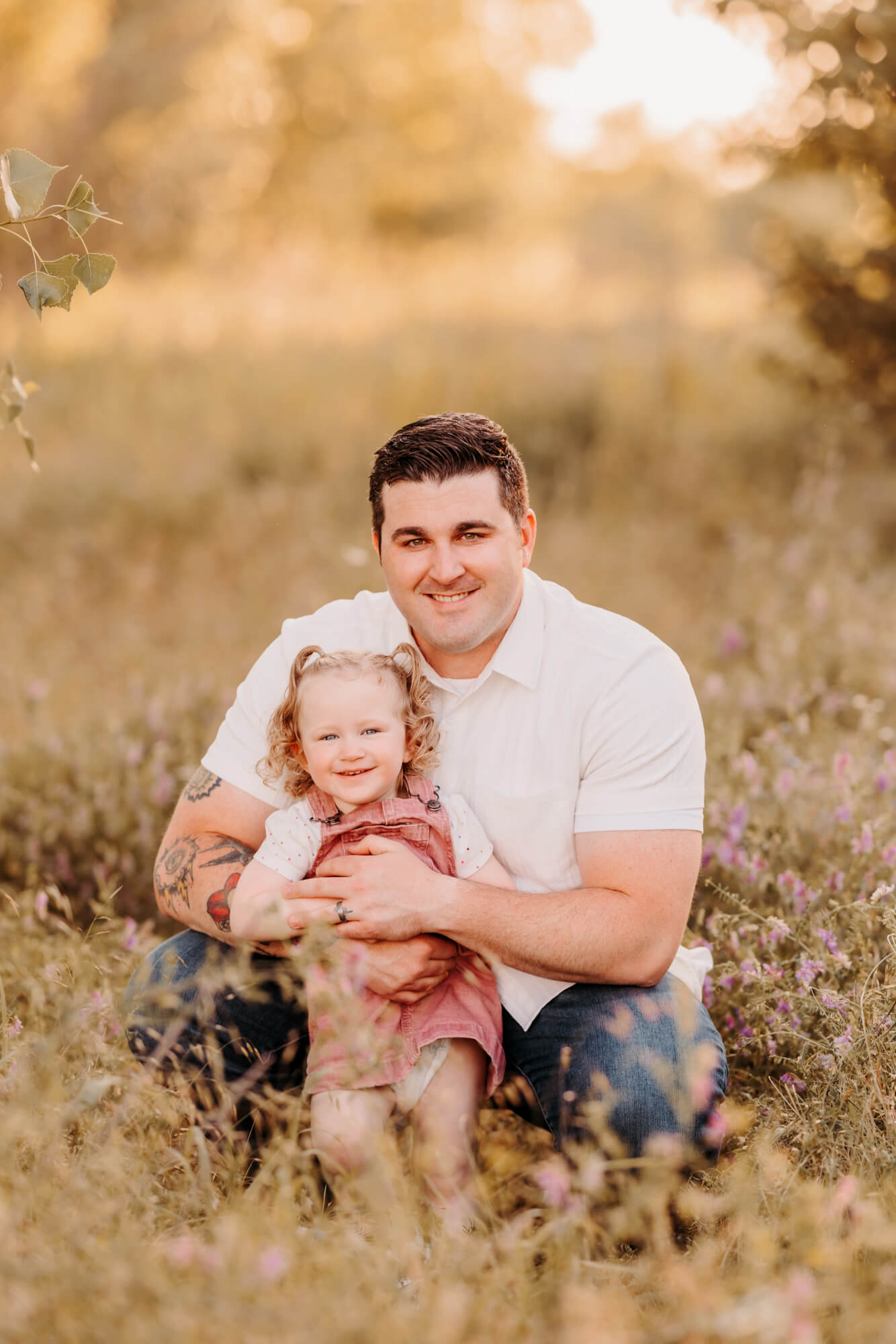 Father squats near his 2 year old daughter for a photo.