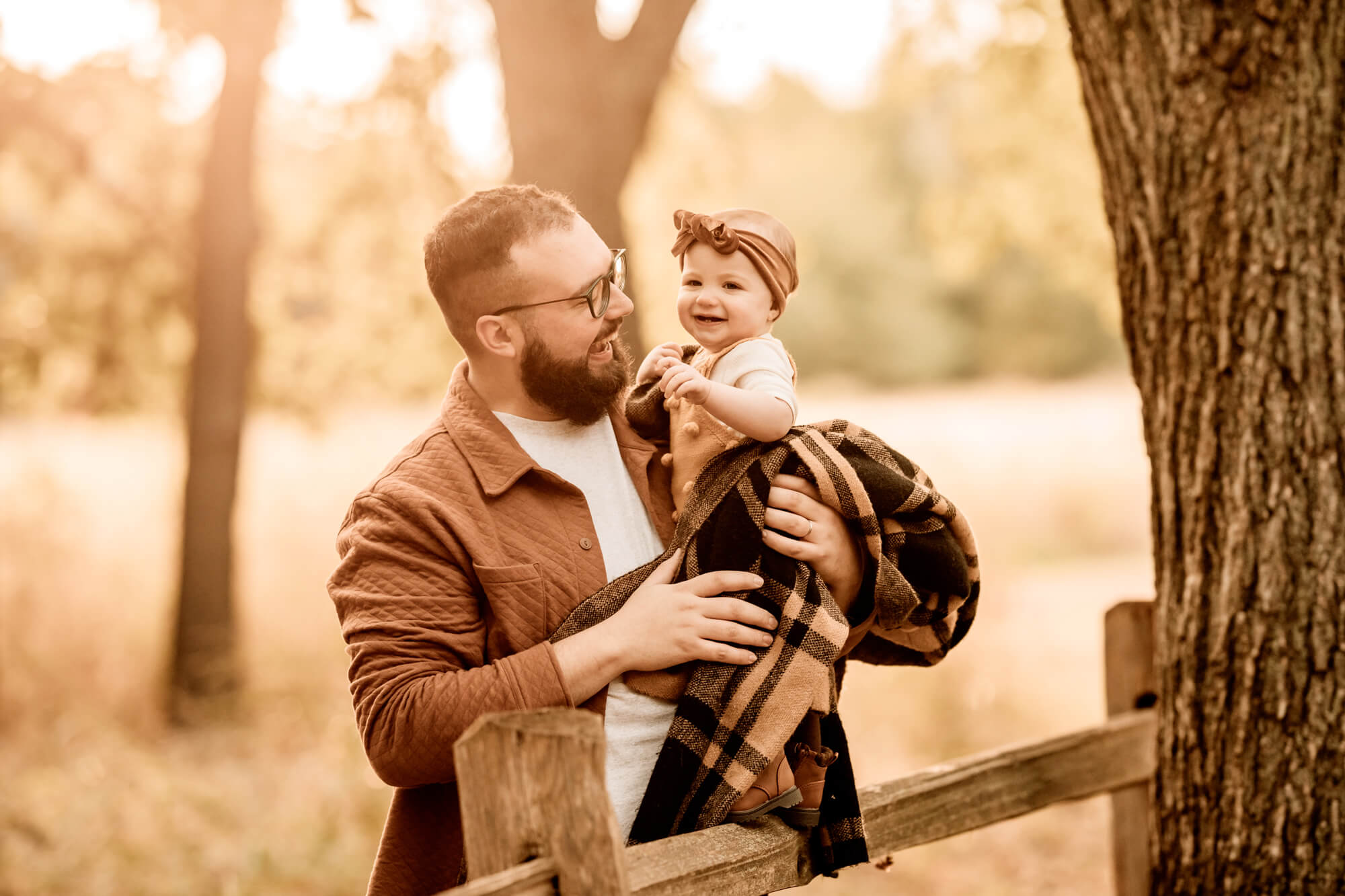 Father holds his daughter wrapped in a blanket, OKC pumpkin patch