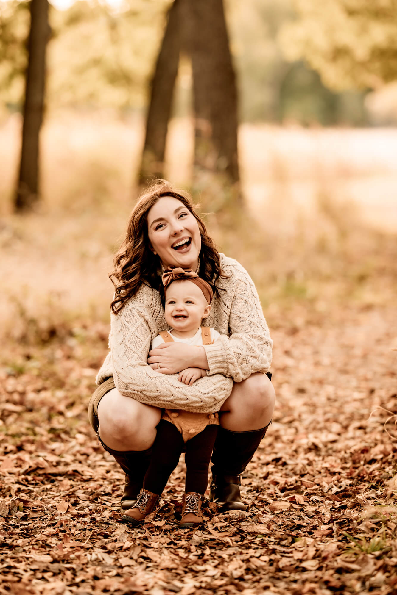 Mother holds her daughter while laughing.