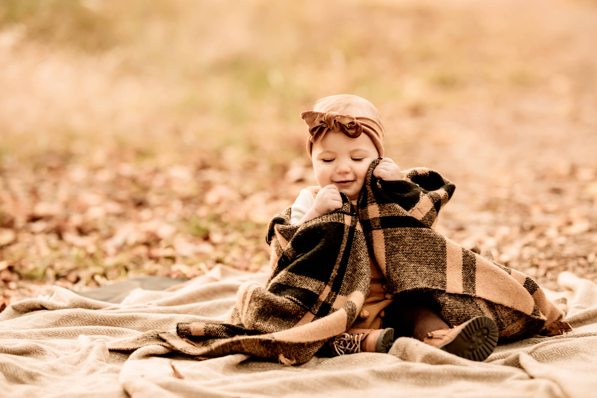 GIrl with a brown wraps a plaid blanket around her, OKC pumpkin patch