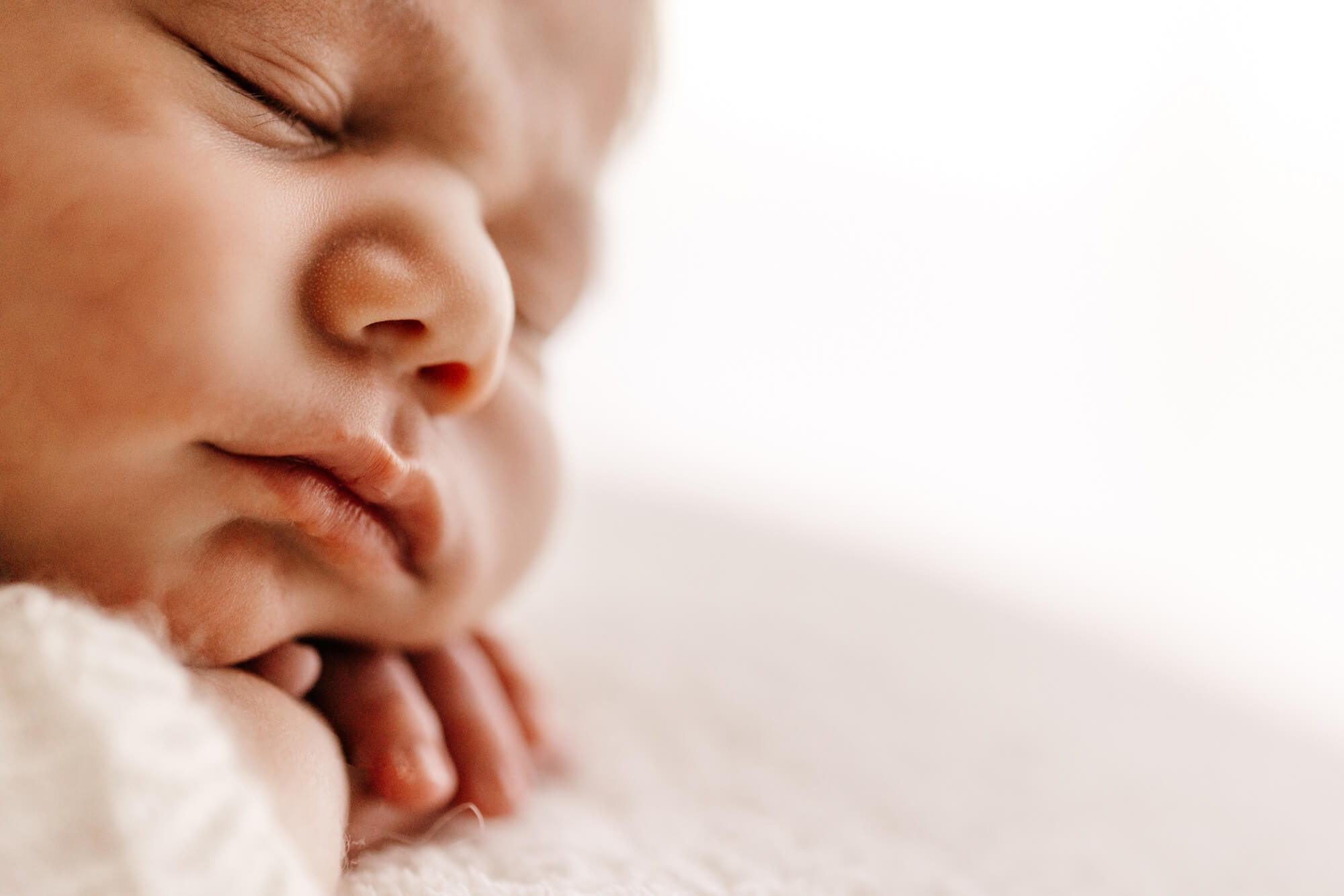 Details of a newborn baby's face as it sleeps before finding infant swim lessons in OKC